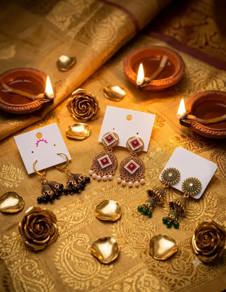 Jewellery pieces arranged with warm diya light and festive fabric.