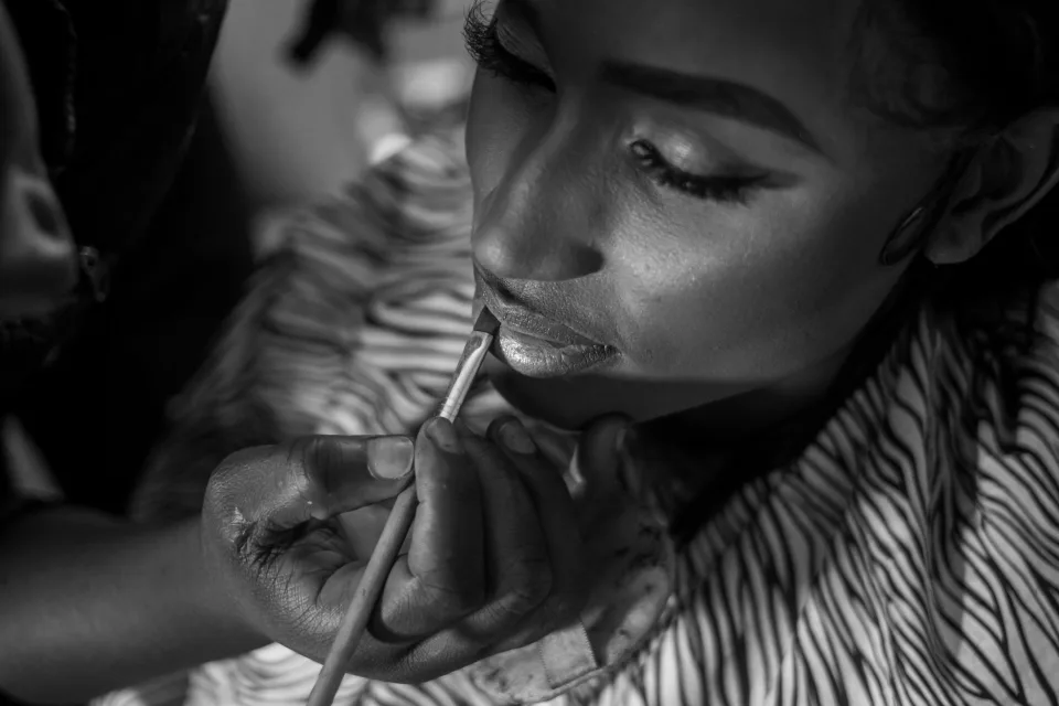 Makeup artist applying lip colour during an SRS makeup session.